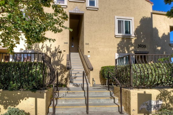 Front view of a multi-story building with stairway entrance.