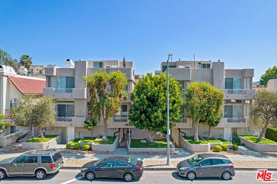 Front view of a multi-story residential building with balconies.