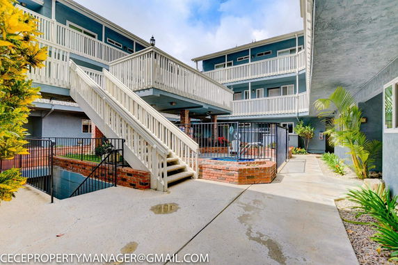 Outdoor area with a small fenced swimming pool and surrounding apartment structure.