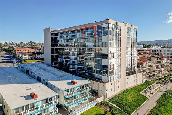 Wide-angle view of a multi-story residential building with balconies and large windows.