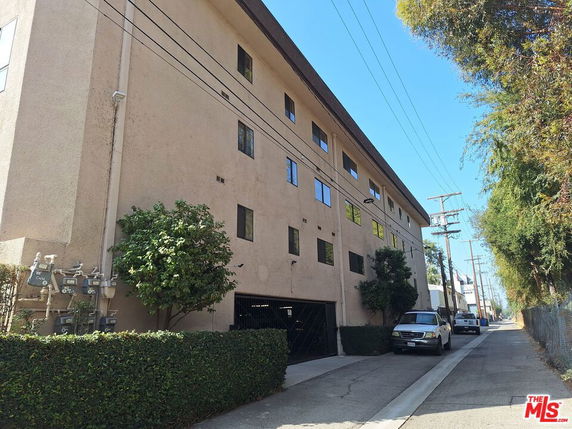 Side view of a multi-story building with several windows and a garage entrance.