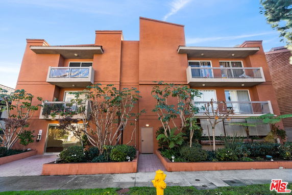 Front view of a multi-story apartment building with balconies.