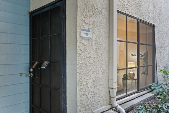 Exterior view of a building entrance with a security door and a large window.