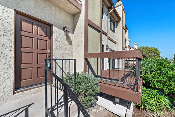 Front view of a townhouse with a brown front door and a small porch area.