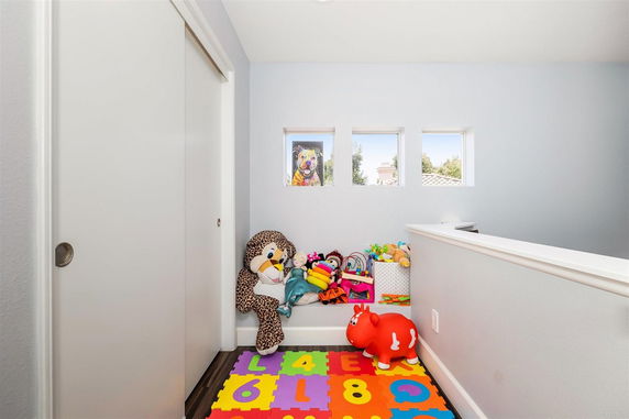 Small indoor play area with toys and colorful foam mat.