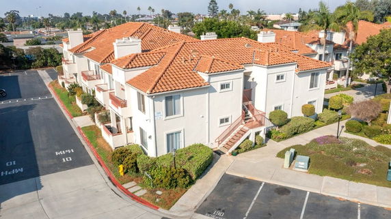 Front view of an apartment complex with red-tiled roofs and white walls.