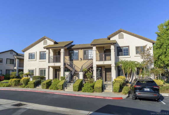 Front view of a two-story residential building with a central staircase and balconies.