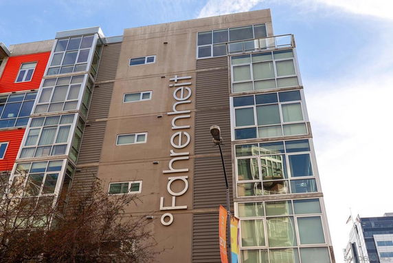 Front view of a multi-story building with modern design and large windows.