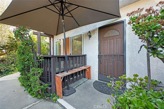 Front view of a house entrance with a wooden door and patio area.
