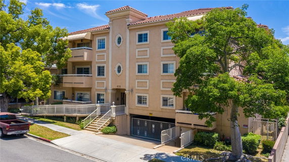 Front view of a multi-story apartment building with balconies.
