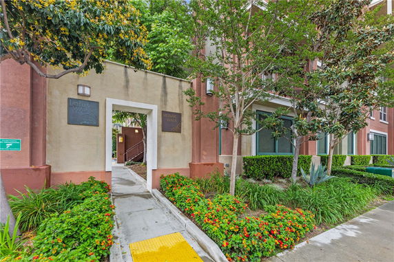 Front view of a residential building entrance with surrounding greenery.