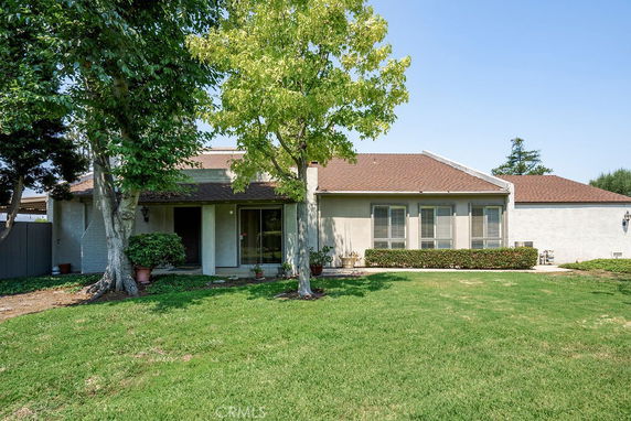 Front view of a single-story house with a sloped roof and large windows.