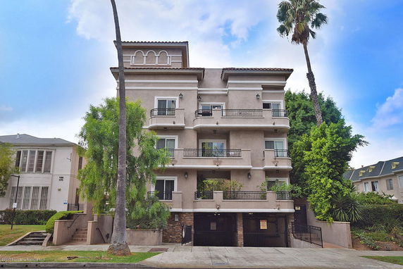 Front view of a multi-story residential building with balconies.