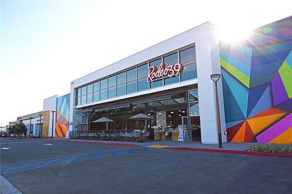 Front view of a modern market building with colorful geometric murals.