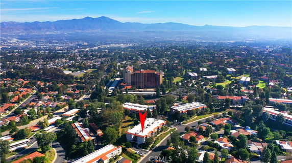 Panoramic view of a residential area with multiple buildings and distant mountains.
