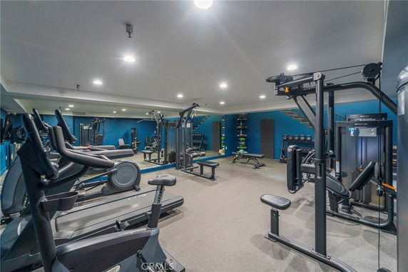 Indoor gym area with various exercise equipment and blue walls.