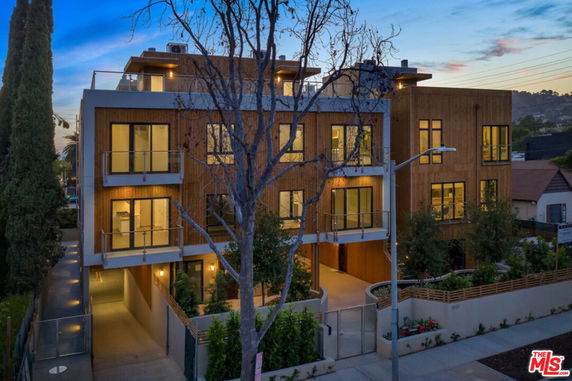 Front view of a modern multi-story building with large windows and balconies.