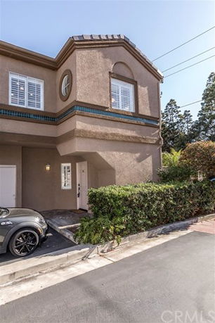 Front view of a two-story house with a small driveway and garage.
