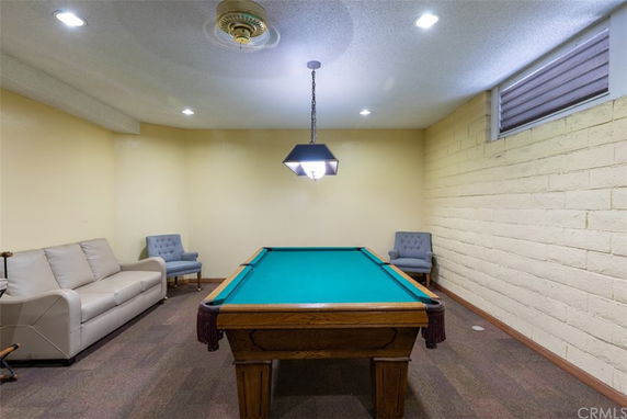 Room with a billiards table and seating area.