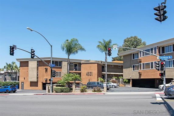 Front view of a multi-story building at a street intersection.