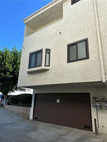 Front view of a multi-story building with a garage on the ground level.