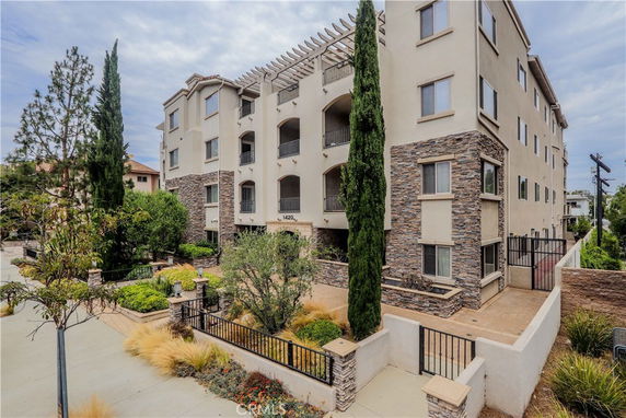 Front view of a multi-story building with stone accents and balconies.