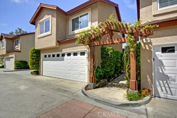 Front view of a two-story house with an attached garage and decorative archway.