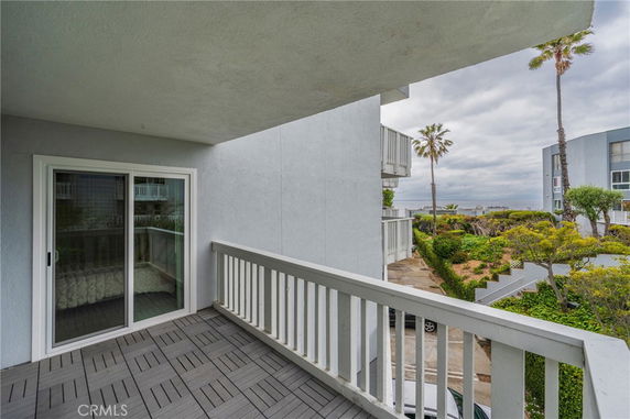 Balcony view from a building with surrounding landscape and nearby structures.