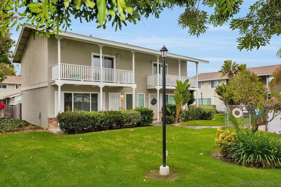 Front view of a two-story house with balconies and large windows.