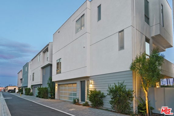 Front view of a modern multi-story townhouse with a garage.