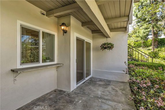 Front view of a house with a covered porch and sliding glass doors.