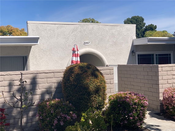 Front view of a single-story house with a flat roof and arched entrance.