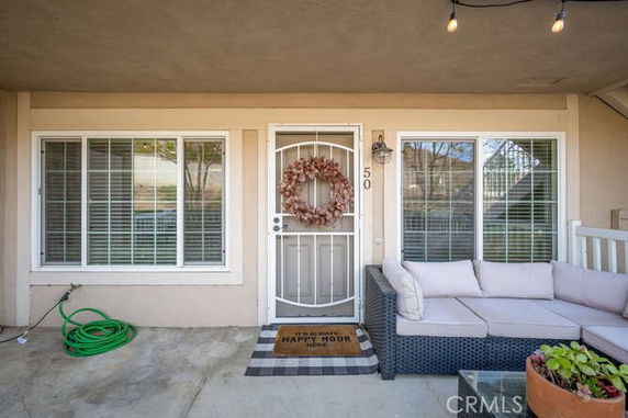 Front view of a house with two large windows and a metal security door adorned with a wreath.
