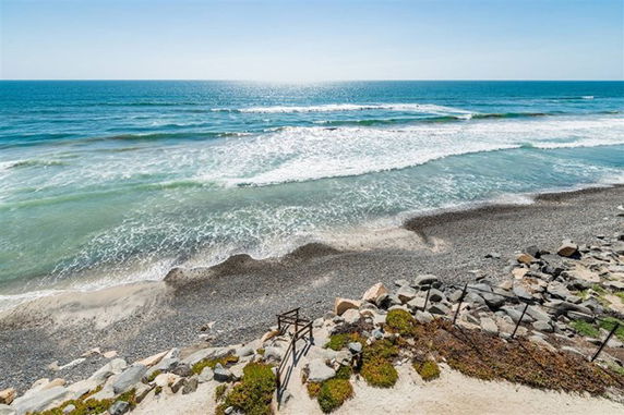 Panoramic view of a rocky shoreline with ocean waves.