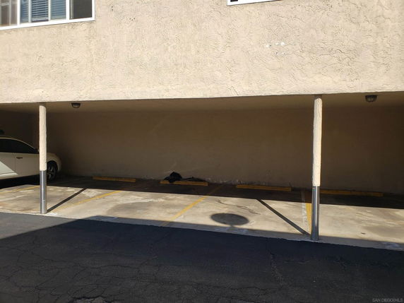 Covered outdoor parking spaces with a partially visible car.