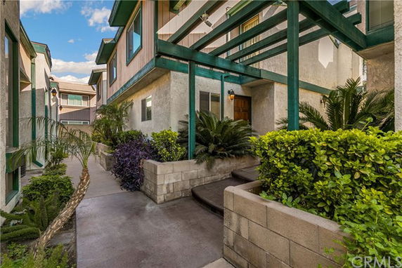 View of a residential courtyard with visible entrances and greenery.