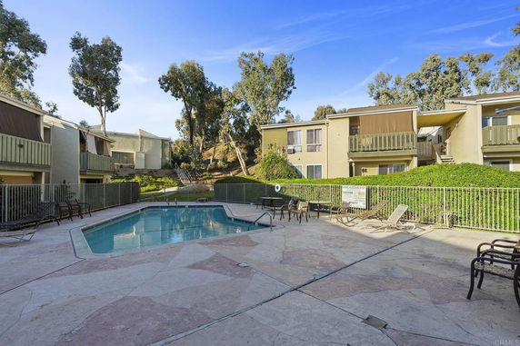 Outdoor swimming pool area with surrounding apartment buildings.