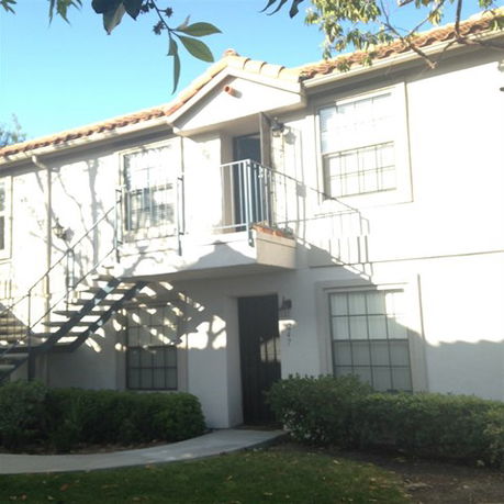 Front view of a two-story residential building with an external staircase.