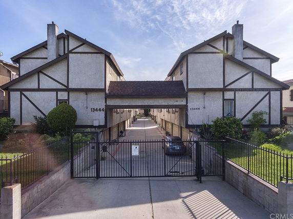 Front view of a two-story building complex with gated entrance.