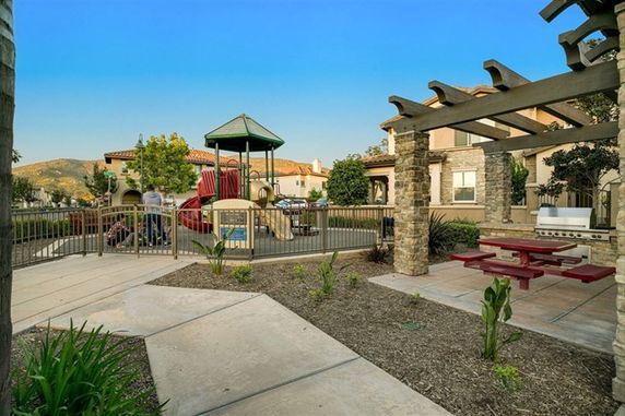 Outdoor play area with playground equipment and seating area.