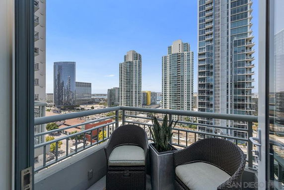 Panoramic view from a balcony overlooking city buildings.