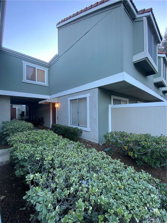 Front view of a two-story house with green siding and white trim.