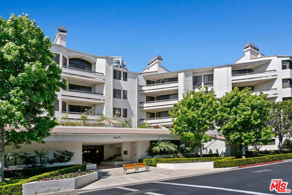 Front view of a multi-story apartment building with balconies.