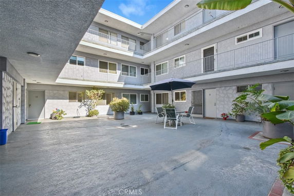 Courtyard of a multi-story building with outdoor seating and potted plants.