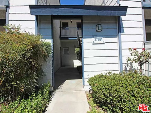 Front view of a two-story building with a walkway.