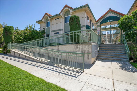 Front view of a building with gable roofs and exterior stairs.