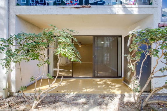 Front view of a building with a ground floor sliding glass door.