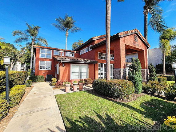 Front view of a two-story house with a large entrance and multiple windows.