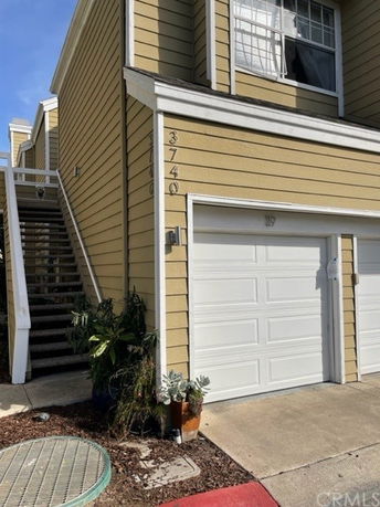 Front view of a house with a beige exterior and attached white garage.