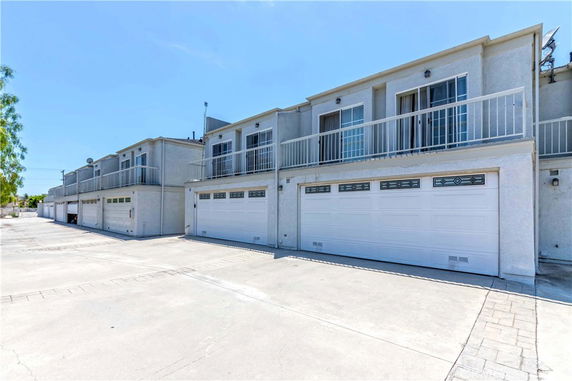 Front view of two-story townhouses with garages on the ground level.
